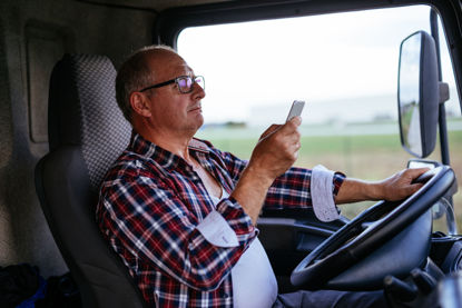 person looking at cell phone while driving