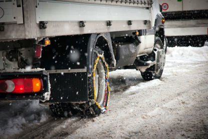 truck with tire chains driving in snow