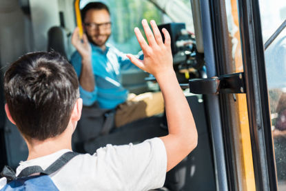 student and driver waving