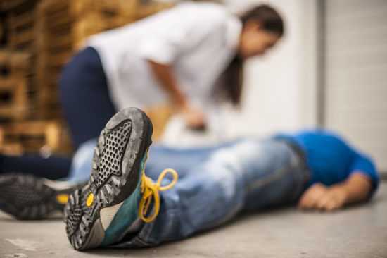 person helping another  person who is lying on the ground