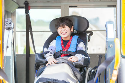 child in wheelchair on bus lift