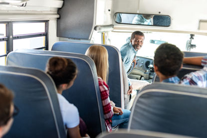 person driving a vehicle looking back at passengers